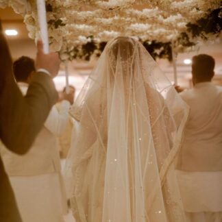 Ivory bridal veil with delicate embellishments and sparkling details, styled for an elegant luxury wedding ceremony