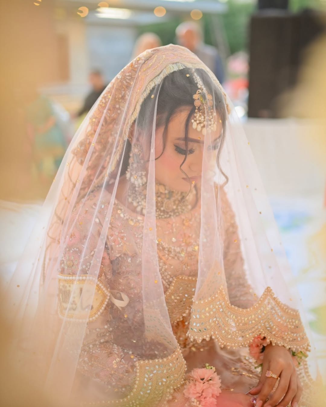 Blush pink cathedral bridal veil with an extra-long sheer train and embellished border for a Pakistani wedding bride.