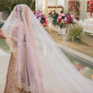 Blush pink cathedral bridal veil with an extra-long sheer train and embellished border for a Pakistani wedding bride.