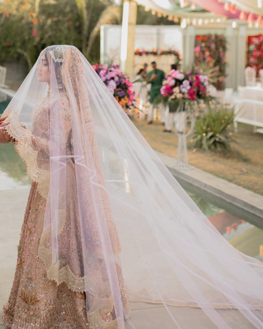 Blush pink cathedral bridal veil with an extra-long sheer train and embellished border for a Pakistani wedding bride.
