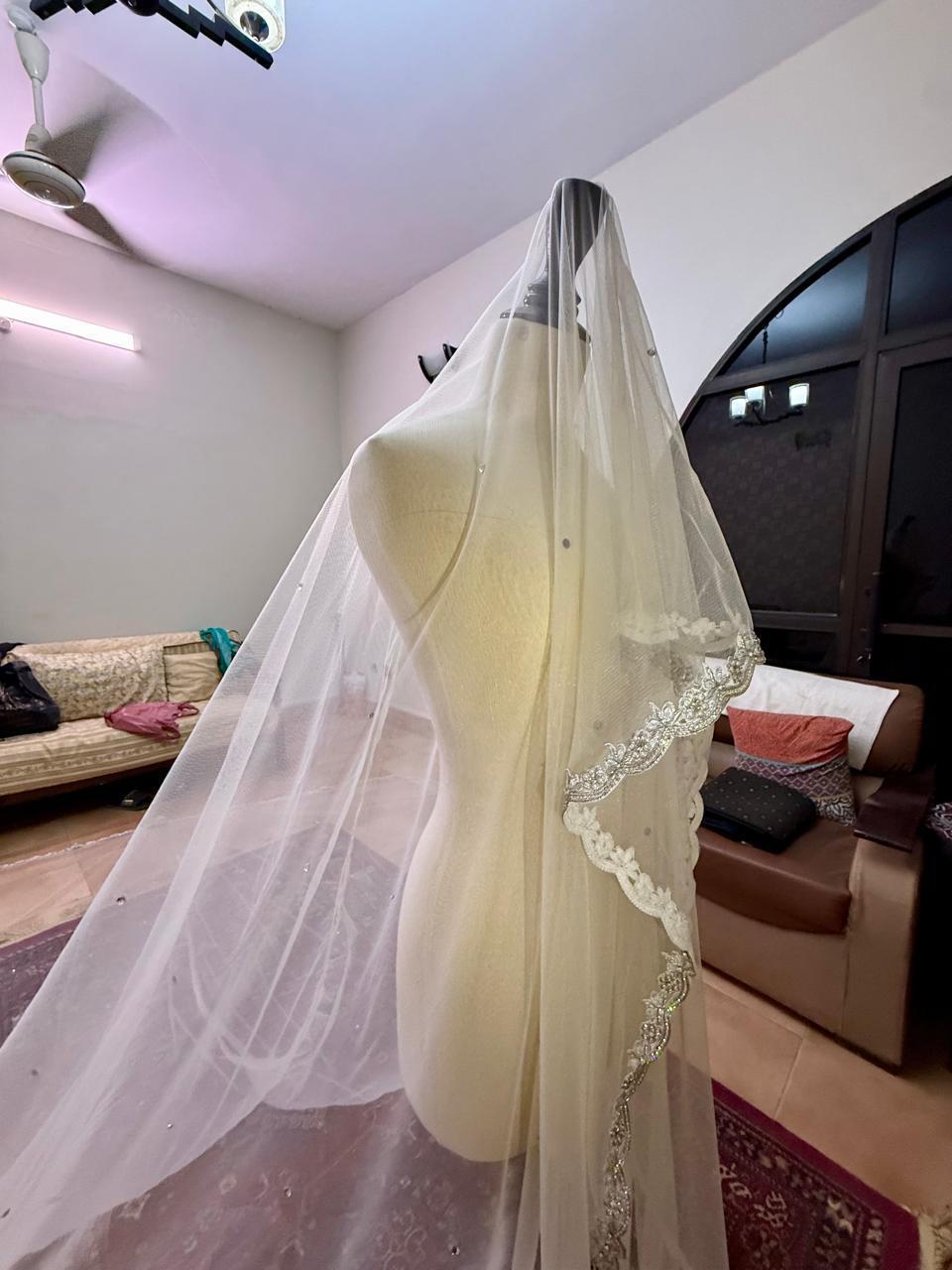 Extra-long ivory bridal veil with delicate sequin embellishments, sheer net fabric and an embroidered lace border for a Nikkah wedding.