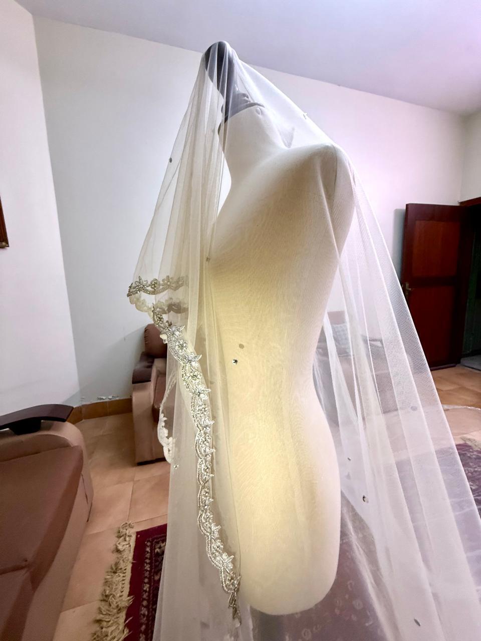 Extra-long ivory bridal veil with delicate sequin embellishments, sheer net fabric and an embroidered lace border for a Nikkah wedding.