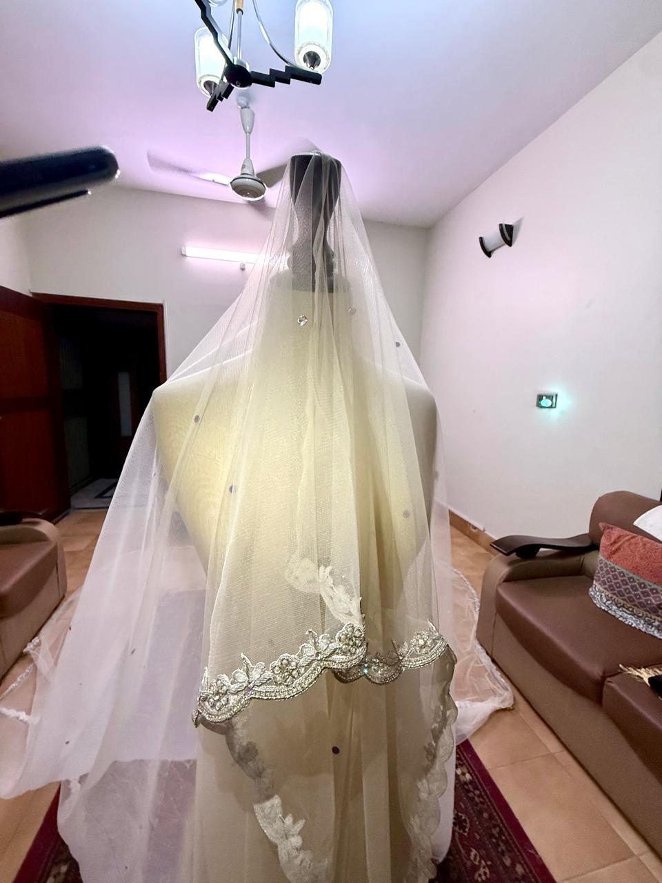 Extra-long ivory bridal veil with delicate sequin embellishments, sheer net fabric and an embroidered lace border for a Nikkah wedding.