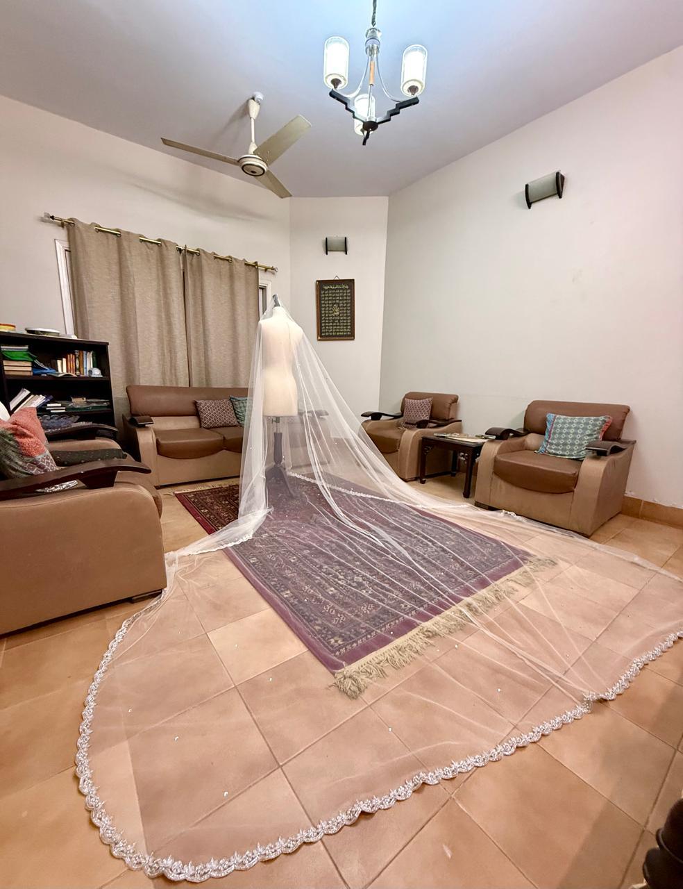 Extra-long ivory bridal veil with delicate sequin embellishments, sheer net fabric and an embroidered lace border for a Nikkah wedding.