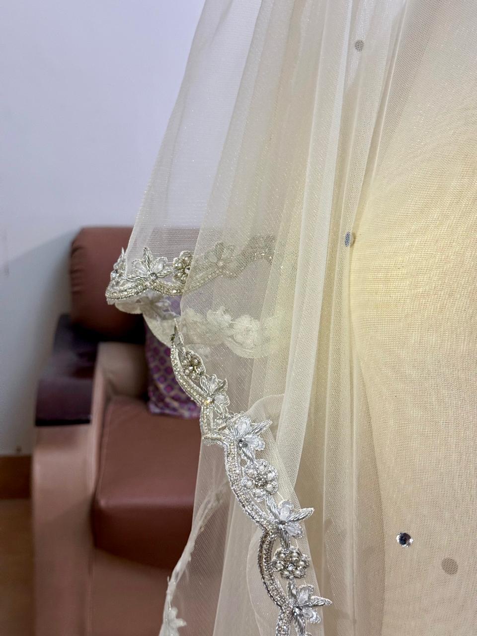 Extra-long ivory bridal veil with delicate sequin embellishments, sheer net fabric and an embroidered lace border for a Nikkah wedding.