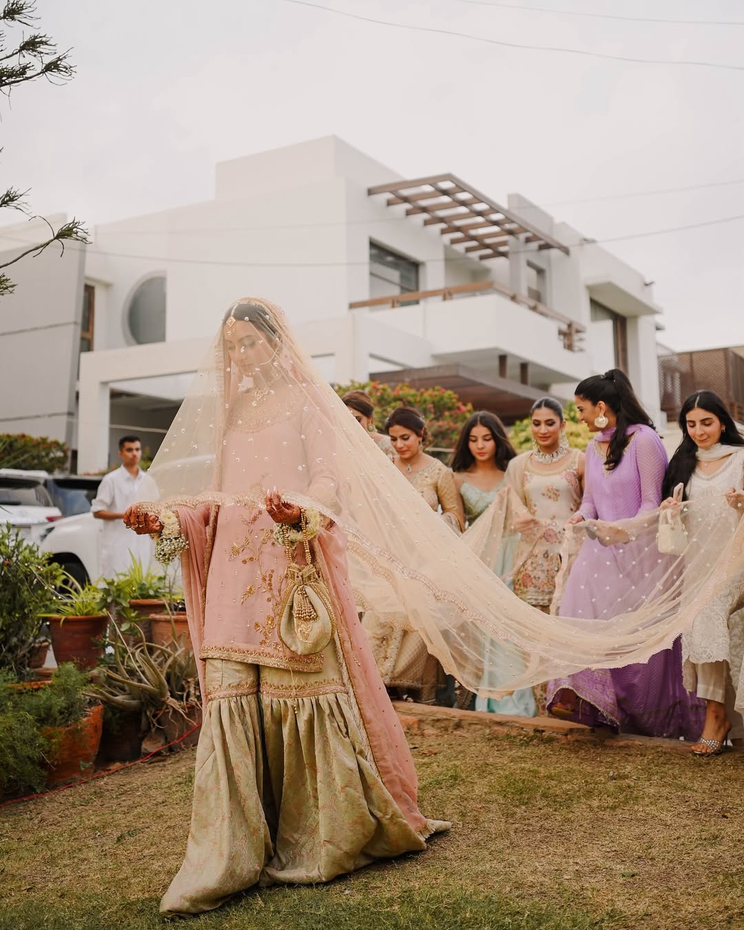 Soft ivory Pakistani bridal dupatta veil with delicate embellishments and long flowing drape styled with a traditional South Asian wedding outfit.