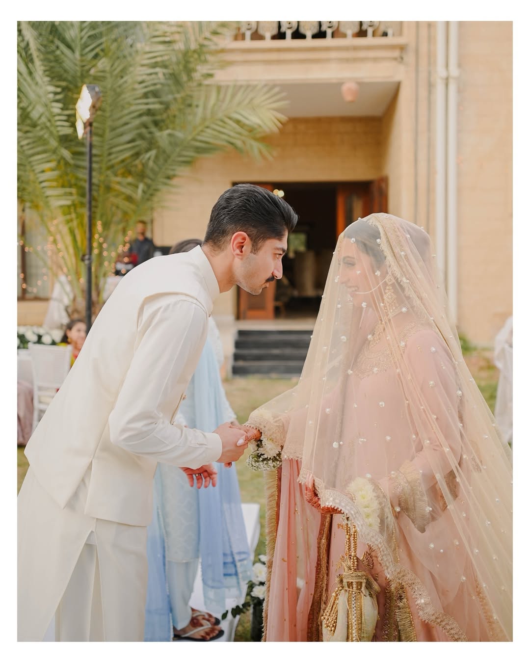 Soft ivory Pakistani bridal dupatta veil with delicate embellishments and long flowing drape styled with a traditional South Asian wedding outfit.