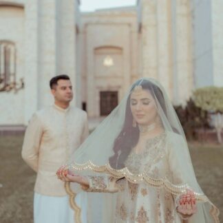 Ivory Pakistani Nikkah dupatta veil with scalloped gold border and reflective detailing styled for a traditional South Asian wedding.