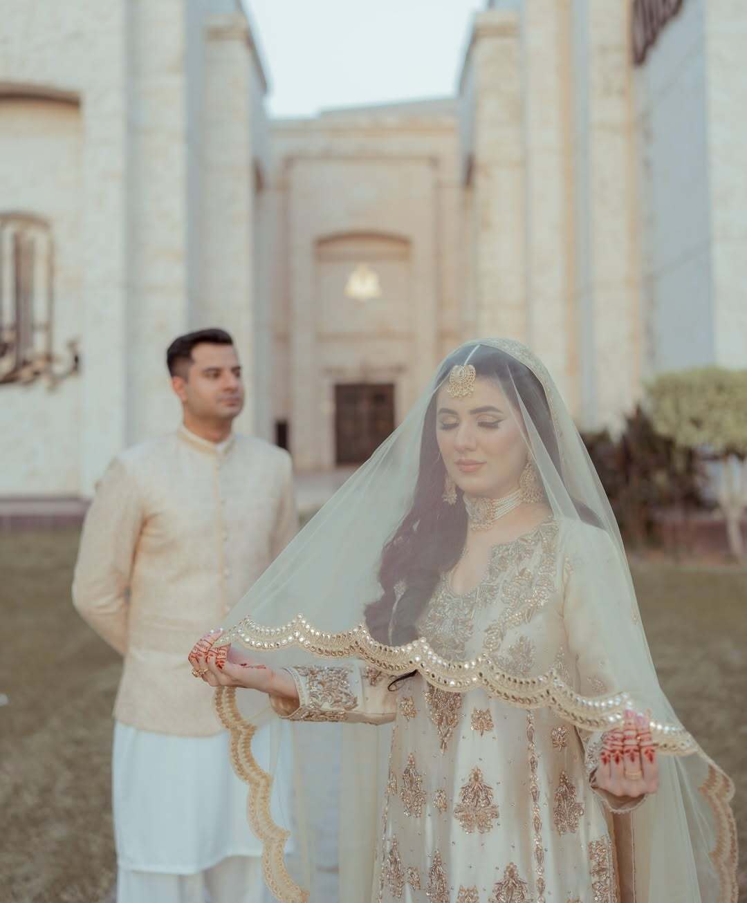 Ivory Pakistani Nikkah dupatta veil with scalloped gold border and reflective detailing styled for a traditional South Asian wedding.