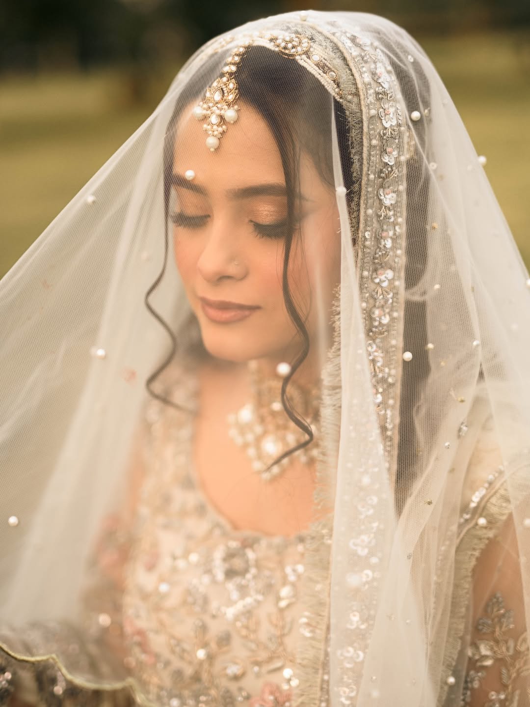 Long Nikkah bridal veil in sheer ivory fabric with delicate embellishments and a flowing train for a Pakistani Muslim wedding.