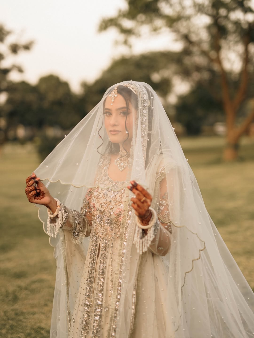 Long Nikkah bridal veil in sheer ivory fabric with delicate embellishments and a flowing train for a Pakistani Muslim wedding.