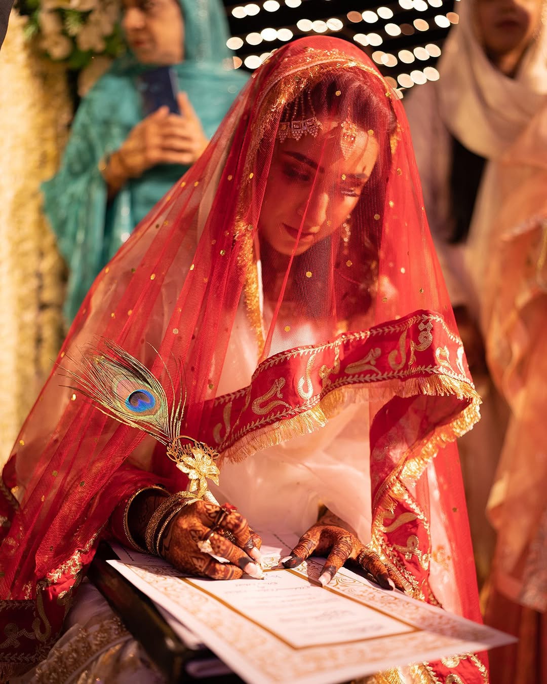Red Nikkah dupatta with gold embroidery, sheer net fabric and decorative fringe border for a Pakistani Muslim bride.