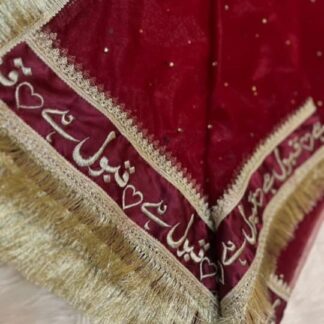Deep red Pakistani Nikkah dupatta with Urdu calligraphy border and gold fringe detailing for a traditional Muslim wedding ceremony.