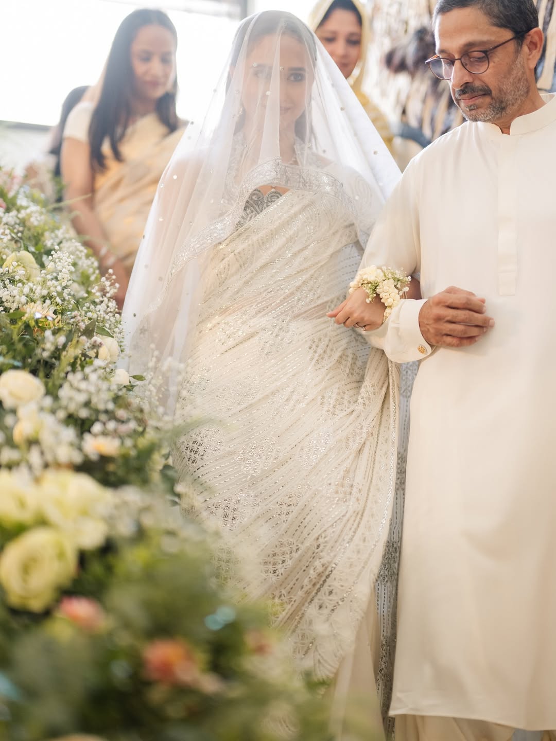 White Pakistani Nikkah dupatta veil with delicate silver detailing and statement border worn by a bride during the Nikkah signing ceremony.