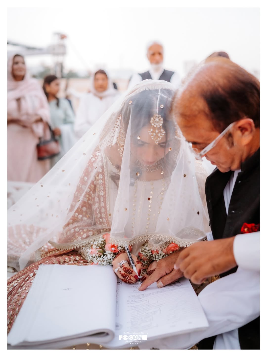 White Pakistani Nikkah dupatta veil with delicate gold detailing and elegant border styled over the head for a traditional Muslim wedding ceremony.