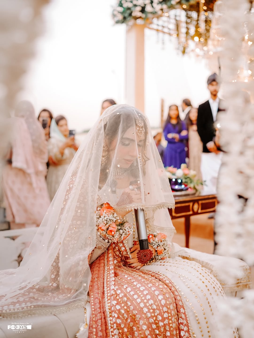 White Pakistani Nikkah dupatta veil with delicate gold detailing and elegant border styled over the head for a traditional Muslim wedding ceremony.
