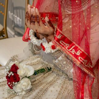 Red Pakistani bridal dupatta veil with personalized Urdu calligraphy border styled for a traditional Nikkah and South Asian wedding.