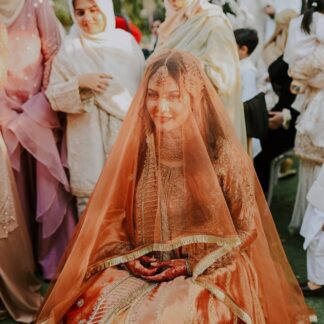 Rust orange bridal veil with sheer fabric and gold fringe border styled for a traditional Pakistani wedding.