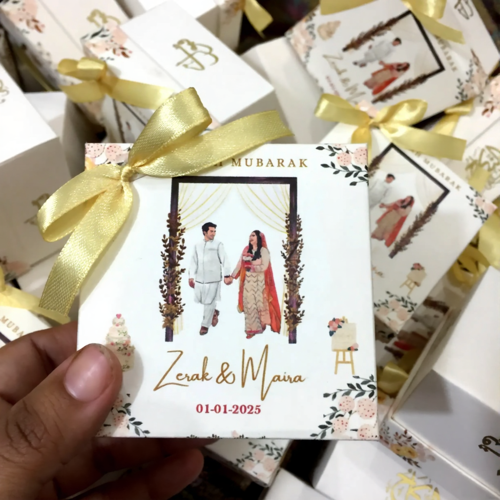 Personalized Nikkah favor boxes with custom couple details, floral decoration and gold satin ribbon for Muslim and Pakistani wedding celebrations.