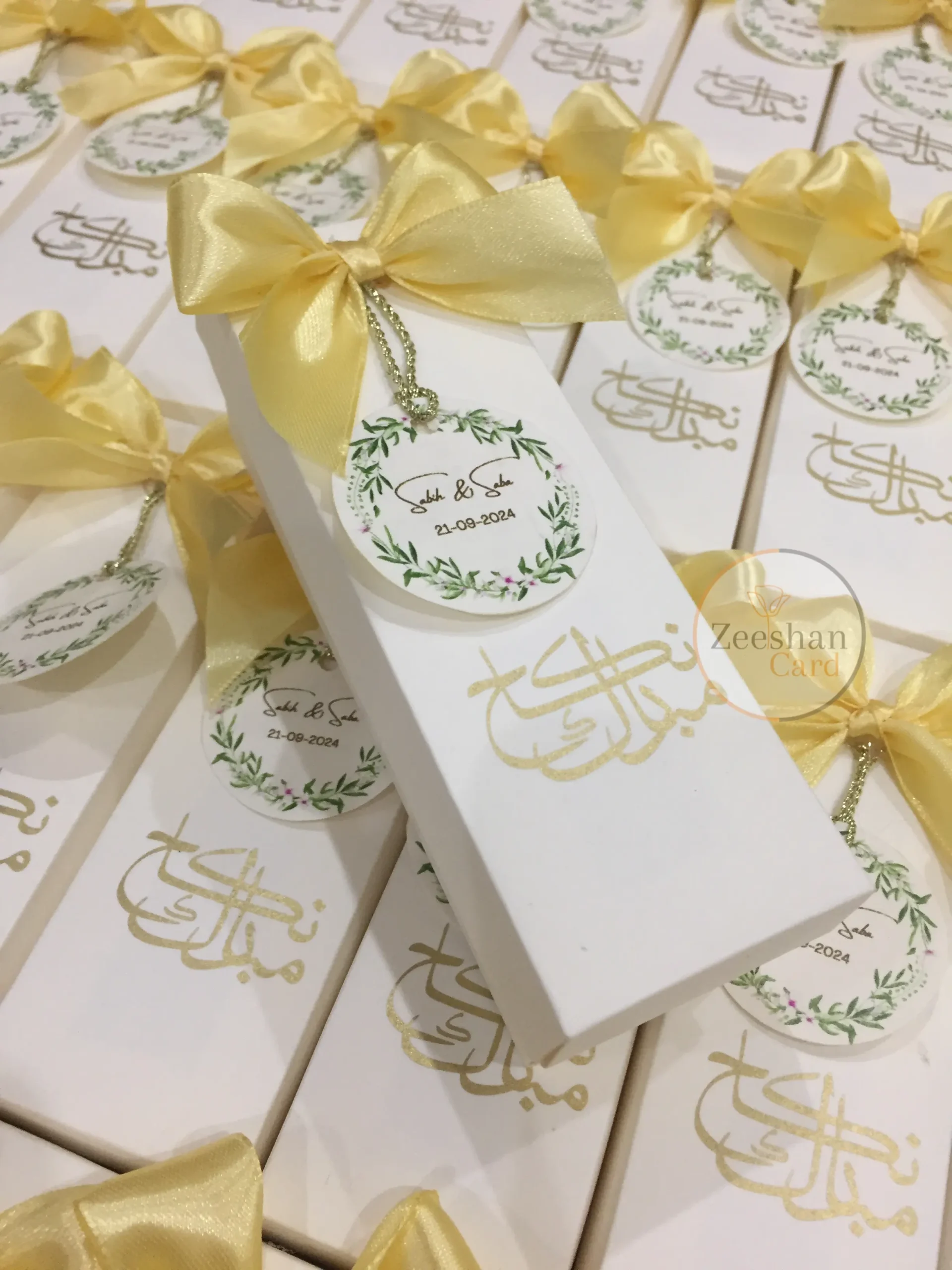 Personalized Nikkah favor boxes with satin bows, custom floral wedding tags and elegant calligraphy for Muslim and Pakistani weddings.