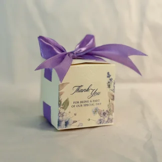 Ivory cube wedding favor box with purple floral details, Thank You message and purple satin bow for Nikkah and Pakistani weddings.