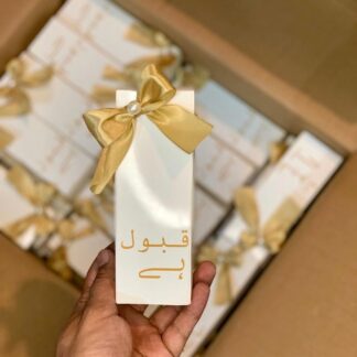 White and gold Qabool Hai favor boxes featuring gold lettering and satin ribbon bows for Nikkah ceremonies, Muslim weddings and Pakistani wedding celebrations