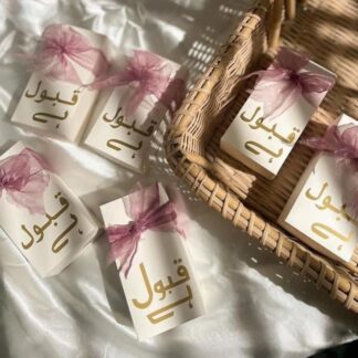 White Qabool Hai favor boxes with gold lettering and blush pink organza ribbon bows for Nikkah ceremonies, Muslim weddings and Pakistani wedding celebrations.