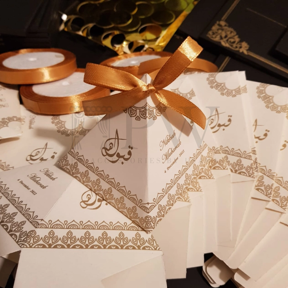 Ivory pyramid Nikkah favor boxes with gold decorative detailing and satin bows for personalized Pakistani and Muslim wedding favors.