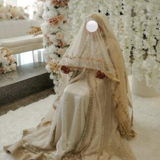 Ivory Pakistani bridal Nikkah dupatta featuring delicate sheer net fabric, gold embroidered borders, shimmering sequins, and Urdu calligraphy, elegantly draped over a Muslim bride during her wedding ceremony.
