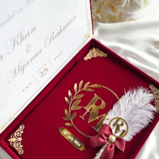 Personalized burgundy velvet Nikkah Nama presentation box featuring gold monogram detailing, custom couple's names, wedding date, decorative signing pen, and elegant ivory marriage announcement for Pakistani and Muslim weddings in the USA.