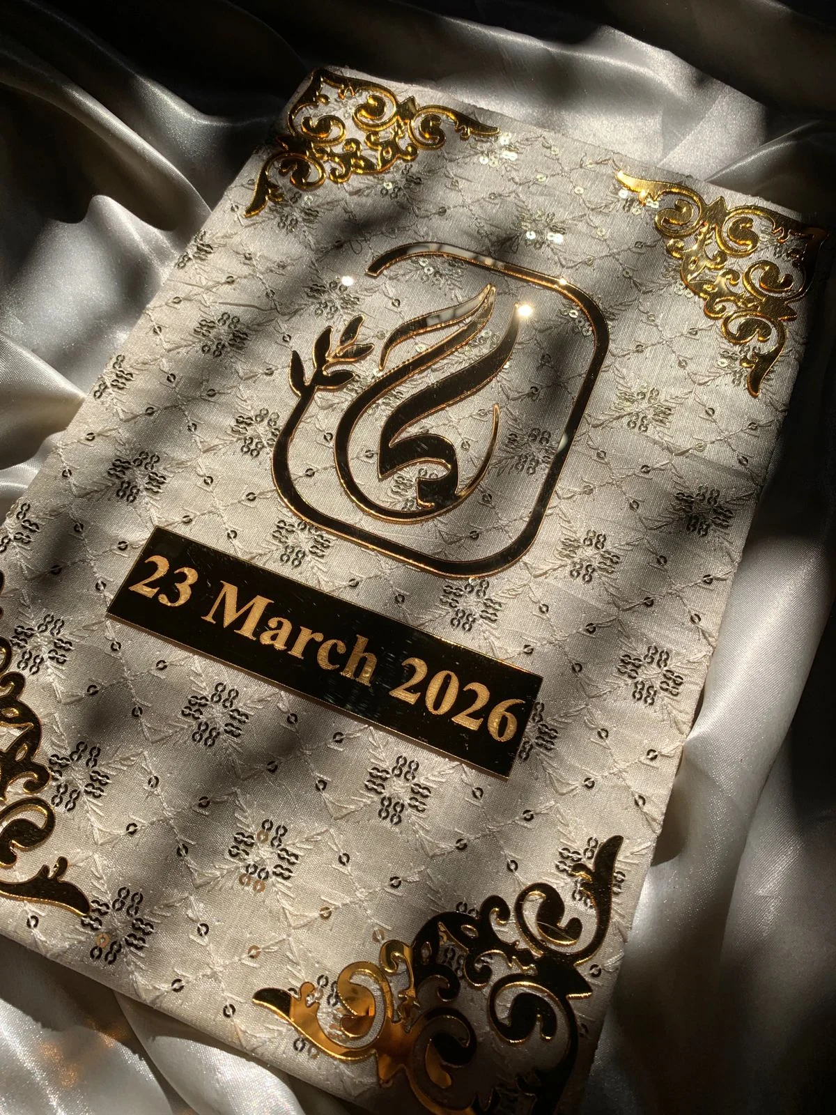 Personalized ivory embroidered Nikkah Nama folder featuring delicate floral embroidery, a metallic gold couple's monogram, custom wedding date plaque, and ornate gold corner embellishments for Pakistani and Muslim wedding ceremonies in the USA.