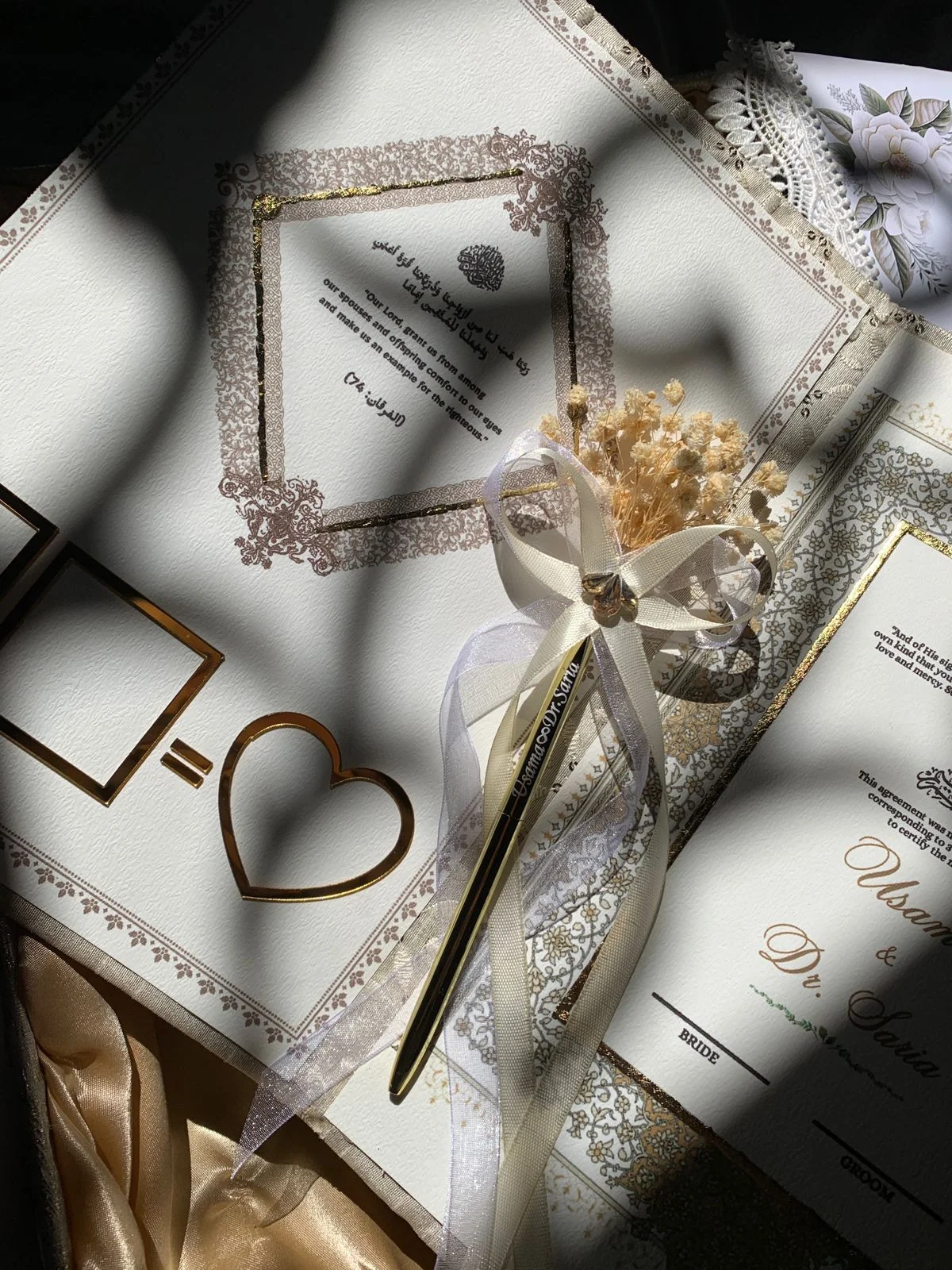 Luxury ivory embroidered Nikkah Nama folder with metallic gold calligraphy, ornate corner decorations, and a decorative signing pen, presented in a champagne-gold satin-lined gift box for Pakistani and Muslim wedding ceremonies.