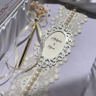 Personalized ivory and gold Nikkah Nama folder featuring Quranic Arabic calligraphy, elegant floral gold borders, custom couple names, Islamic marriage details, bride and groom signature spaces, and a decorative gold signing pen with ivory ribbons for Pakistani and Muslim weddings.