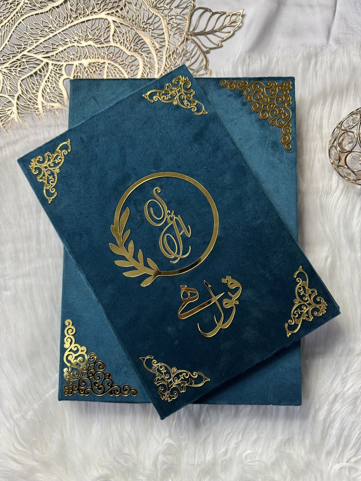 Personalized Nikkah Nama marriage certificate with intricate gold Islamic borders, Arabic calligraphy, and traditional bride-and-groom illustration inside a luxury teal blue folder.