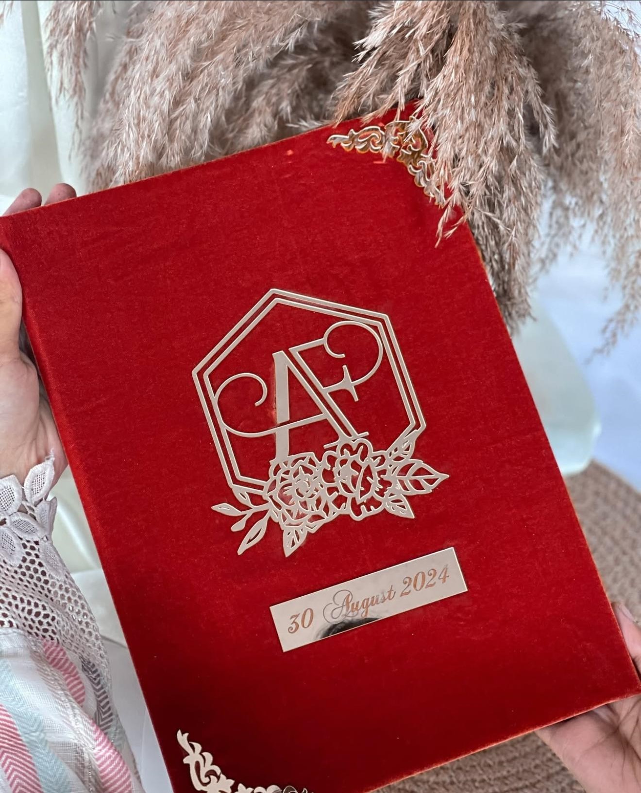 Personalized red velvet Nikkah Nama folder featuring a silver-toned floral monogram with couple's initials and a custom wedding date plaque for Pakistani Muslim wedding ceremonies in the USA.