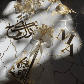 Personalized white and gold marble Nikkah Nama folder featuring reflective gold couple initials, intricate ornamental gold corners, elegant marble-inspired veining, decorative floral signing pen, and champagne satin-lined presentation box for Pakistani and Muslim weddings in the USA.