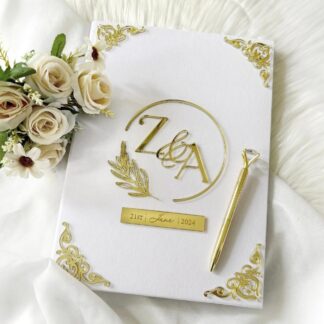 Personalized white Nikkah Nama folder with elegant gold floral monogram, custom couple initials, wedding date plaque, and intricate gold corner embellishments for Pakistani and Muslim wedding ceremonies in the USA.